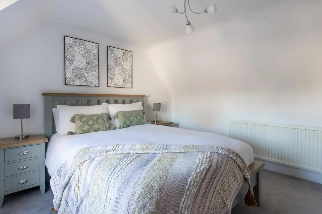 a bedroom with a bed and two pictures on the wall at Hill Street Haven in Inverness