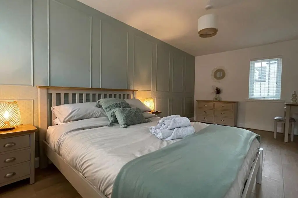 a bedroom with a large bed with towels on it at Harbourside by Caithness Luxury Apartments NC500 - 2 Bedroom holiday home - Sleeps Work teams upto 2 & holiday makers upto 6 with bike store in Wick