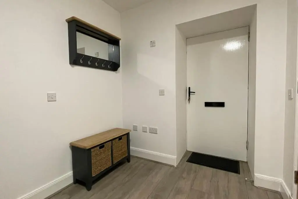 a hallway with a television on a wall and a door at Harbourside by Caithness Luxury Apartments NC500 - 2 Bedroom holiday home - Sleeps Work teams upto 2 & holiday makers upto 6 with bike store in Wick