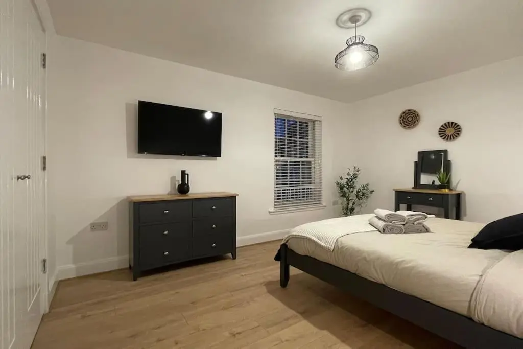 a bedroom with a bed and a flat screen tv at Harbourside by Caithness Luxury Apartments NC500 - 2 Bedroom holiday home - Sleeps Work teams upto 2 & holiday makers upto 6 with bike store in Wick