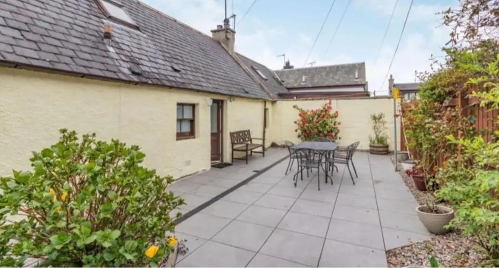 a patio with a table and chairs in a backyard at North Coast Property - 17 Margaret Street - Avoch in Avoch