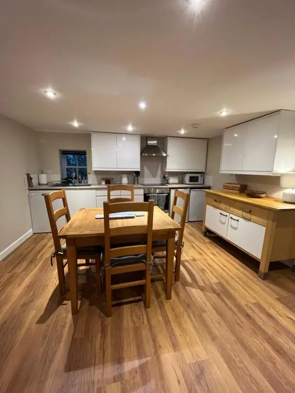 a kitchen with a wooden table and chairs at North Coast Property - 17 Margaret Street - Avoch in Avoch