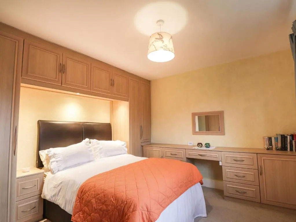 a bedroom with a large bed with an orange blanket at Tommy's in Inverness
