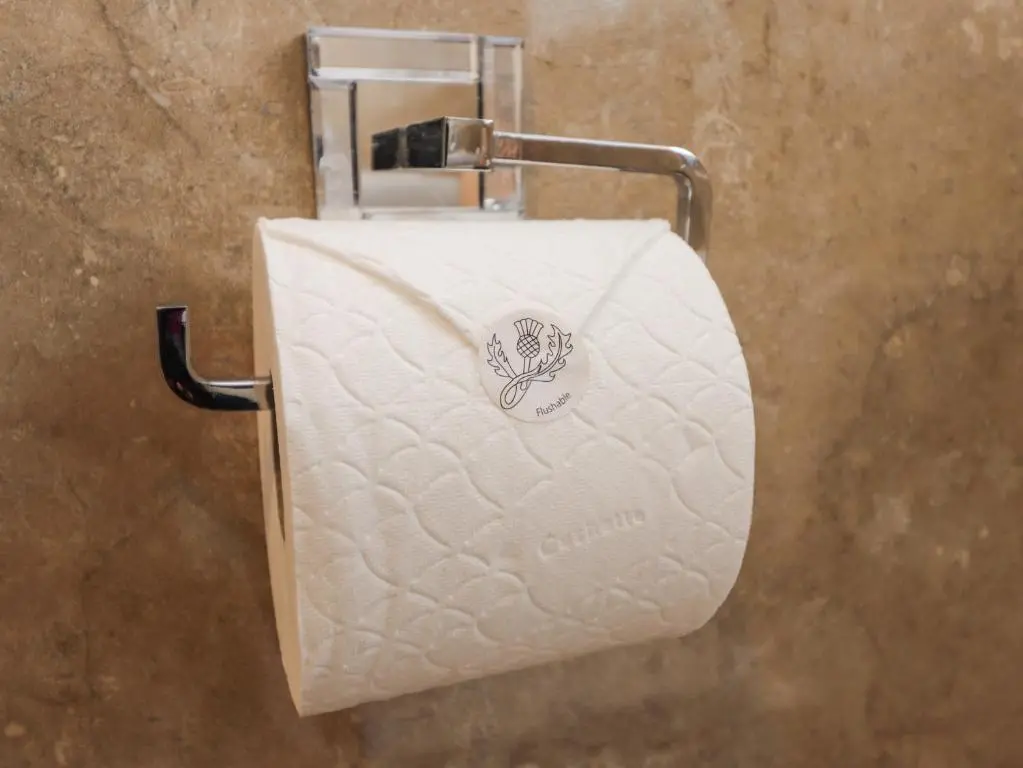 a roll of toilet paper on a holder in a bathroom at Tommy's in Inverness