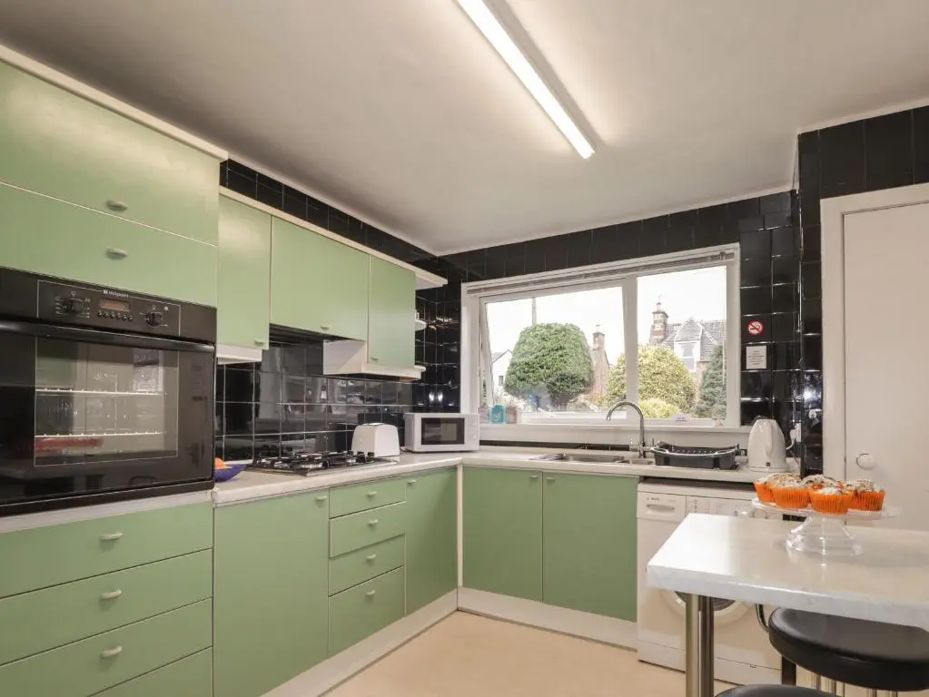 a kitchen with green cabinets and a table at Tommy's in Inverness