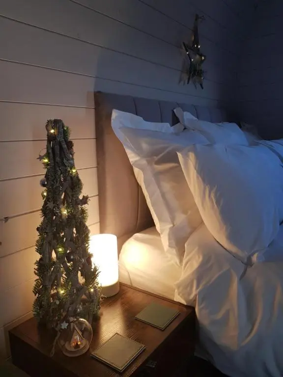 a christmas tree on a table next to a bed at Dunbeath Coastal Retreat in Dunbeath