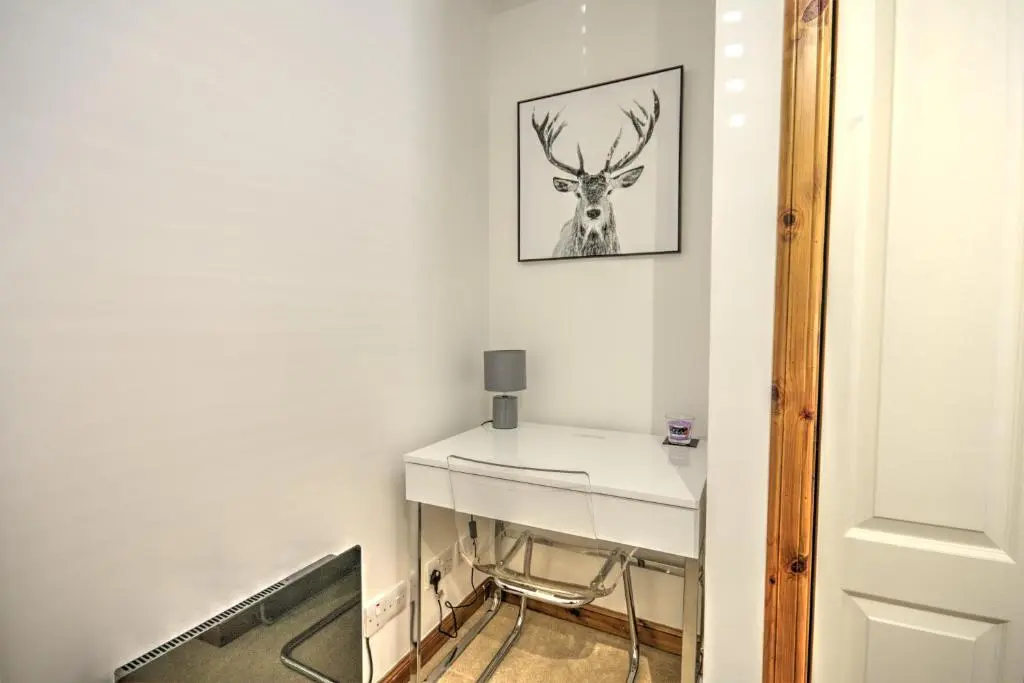 a room with a white desk with a deer on the wall at 5 Argyle Place, Dornoch in Dornoch