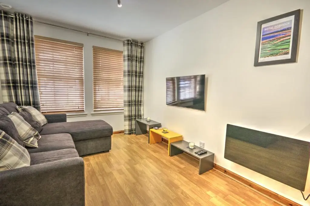 a living room with a couch and a flat screen tv at 5 Argyle Place, Dornoch in Dornoch
