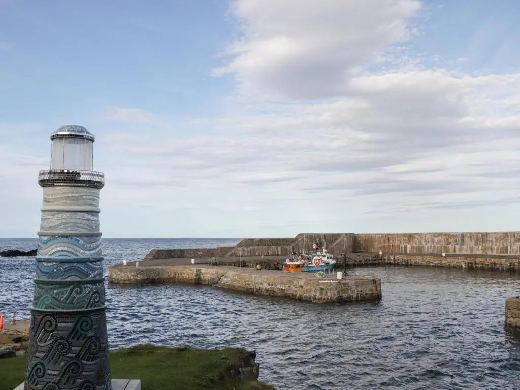 a lighthouse in the water next to a pier at 2 Seafield Place in Portsoy