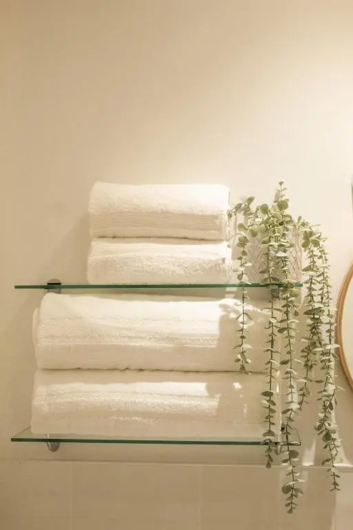 four towels on a glass shelf in a bathroom at Dalnaglar in Nethy Bridge