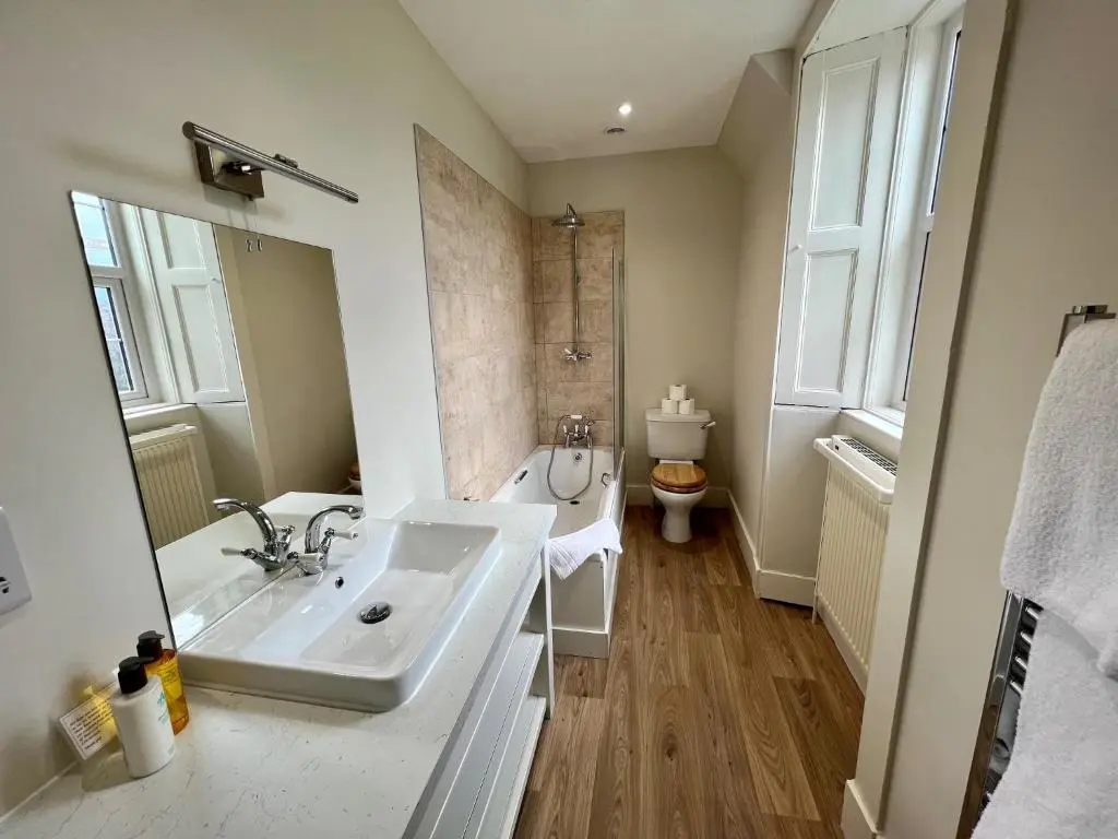 a bathroom with a sink and a tub and a toilet at St Marys Farmhouse - Traditional Country Farmhouse with Open Fire in Fochabers