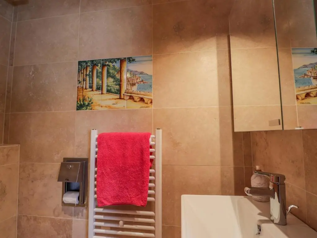 a bathroom with a sink and a red towel at Lossiemouth Bay Cottage in Lossiemouth