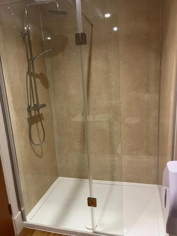 a shower with a glass door in a bathroom at Great Glen Hostel in Spean Bridge