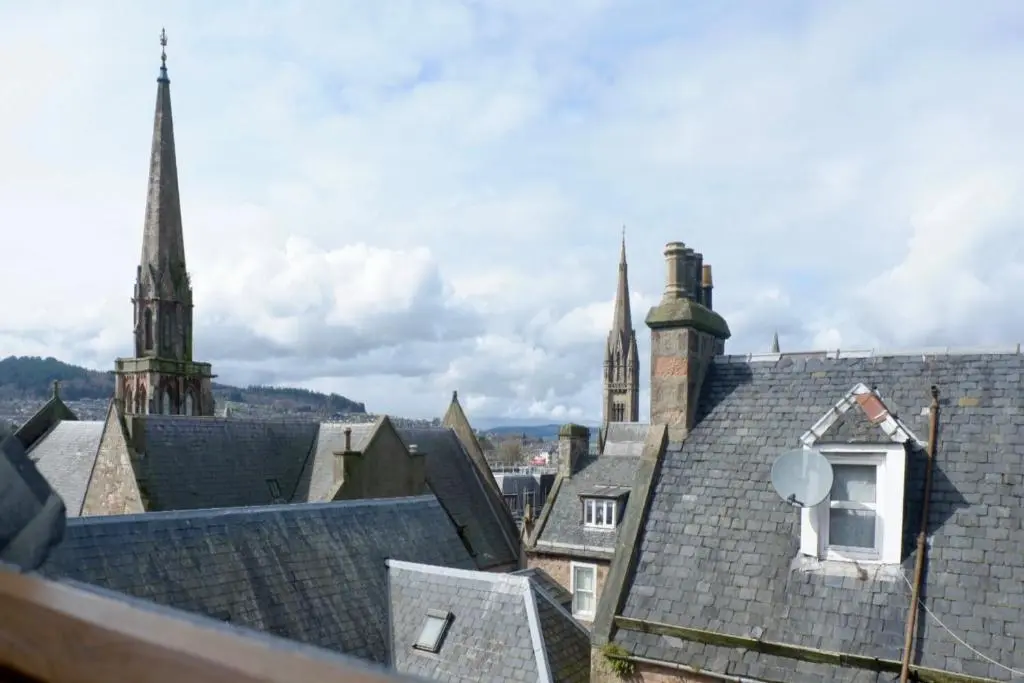 a view of roofs of buildings with a church at Jacobite house in Inverness