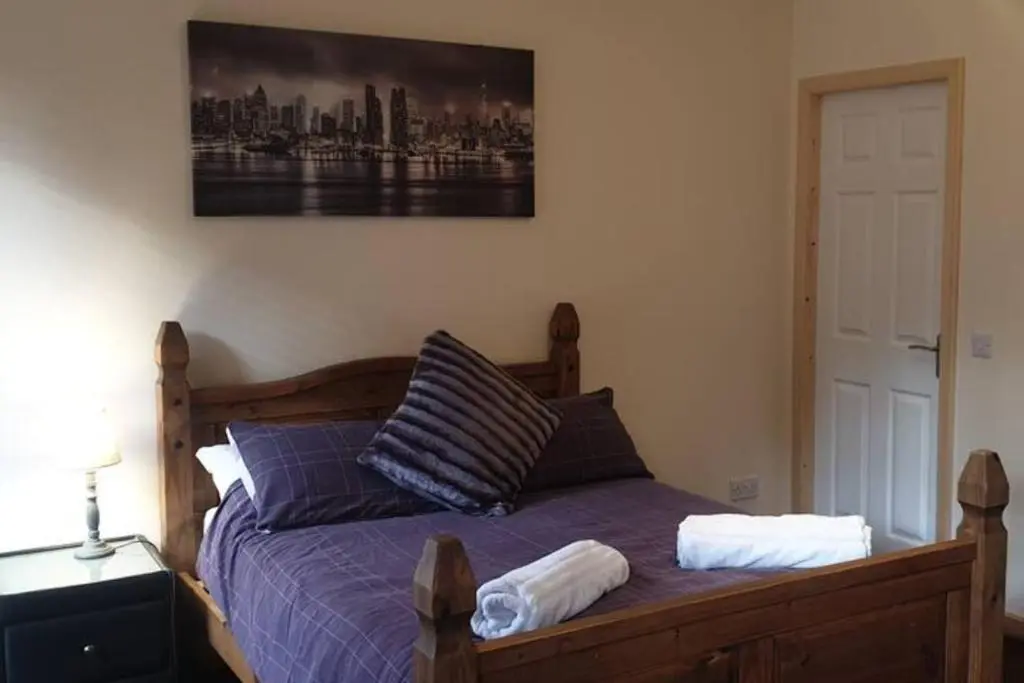 a bed with two pillows and a painting on the wall at Ensuite Rooms in Wick