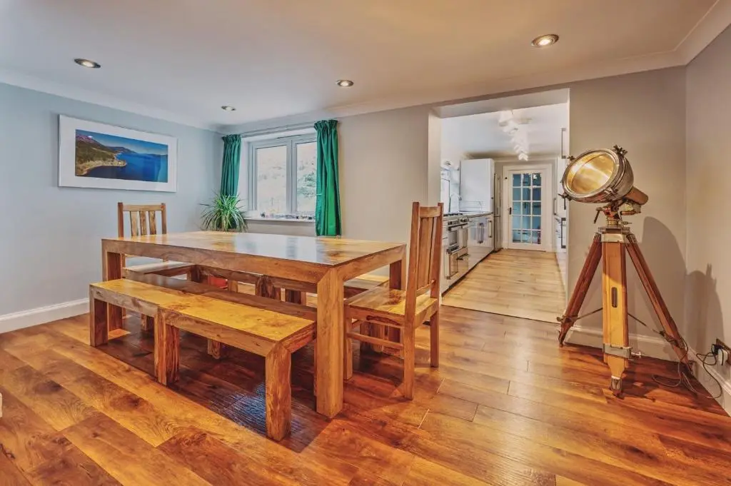 a dining room with a table and a telescope at Loch Ness Mansion in Invermoriston