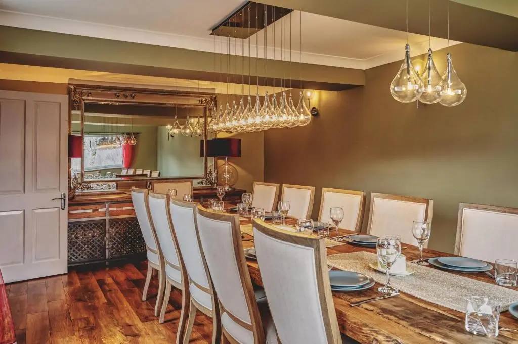 a dining room with a long table and chairs at Loch Ness Mansion in Invermoriston