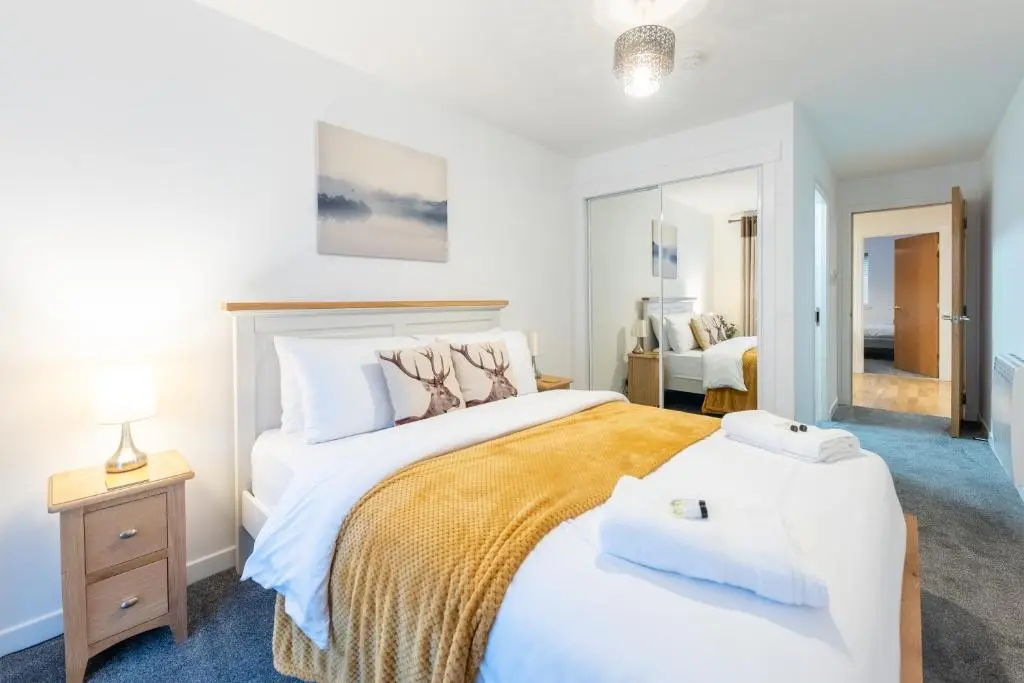 a bedroom with a large bed and a mirror at Modern City Centre Apartment in Inverness in Inverness