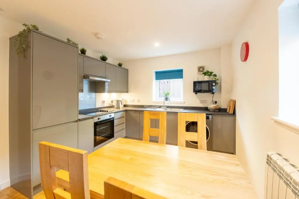 a kitchen with stainless steel appliances and wooden floors at Modern City Centre Apartment in Inverness in Inverness