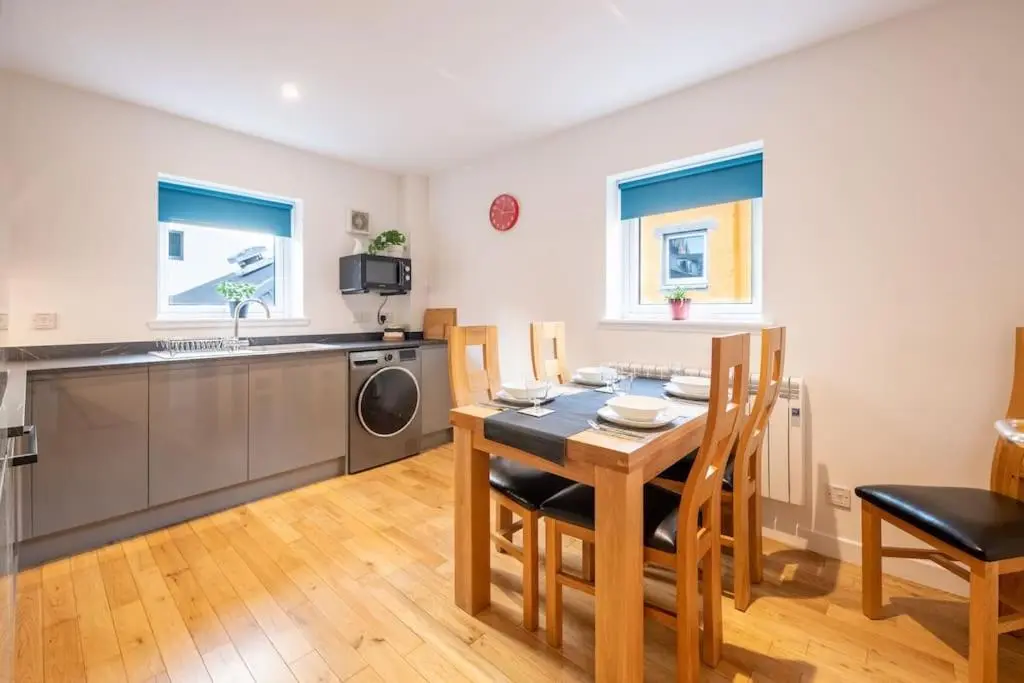 a kitchen and dining room with a table and chairs at Modern City Centre Apartment in Inverness in Inverness