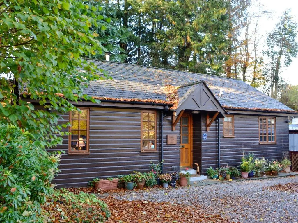 a small house with a gray house at Toll Bridge Lodge in Banchory