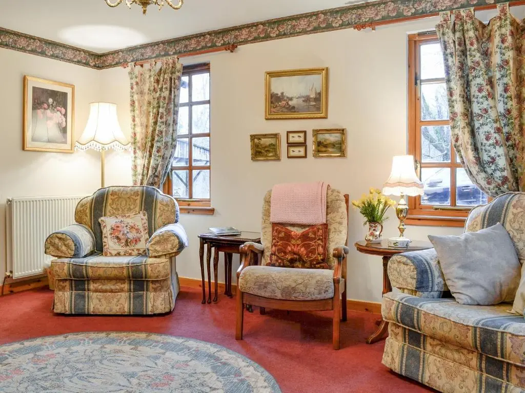 a living room with two chairs and a couch at Toll Bridge Lodge in Banchory