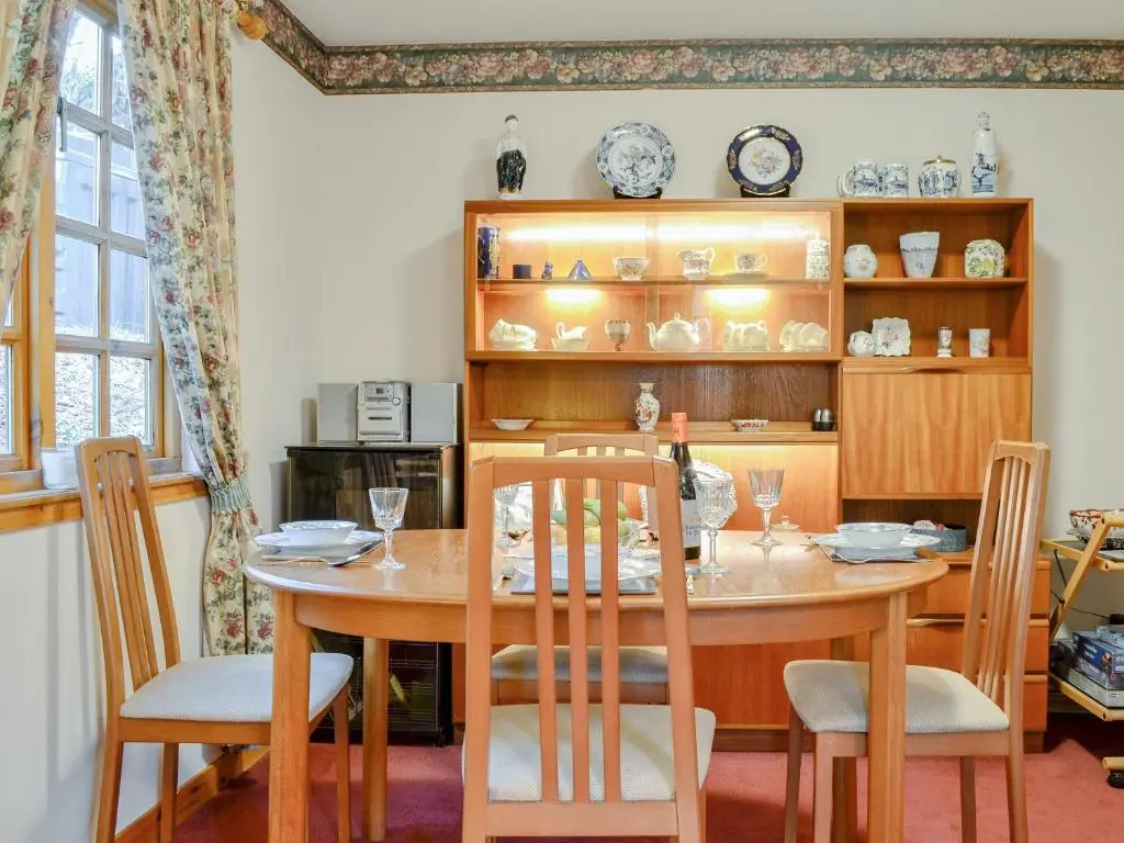 a dining room with a table and chairs at Toll Bridge Lodge in Banchory