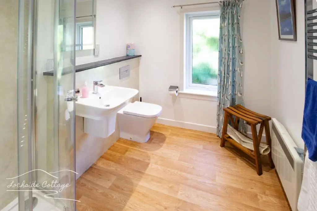 a bathroom with a sink and a toilet and a shower at Lochside Cottage - near Aviemore in Aviemore