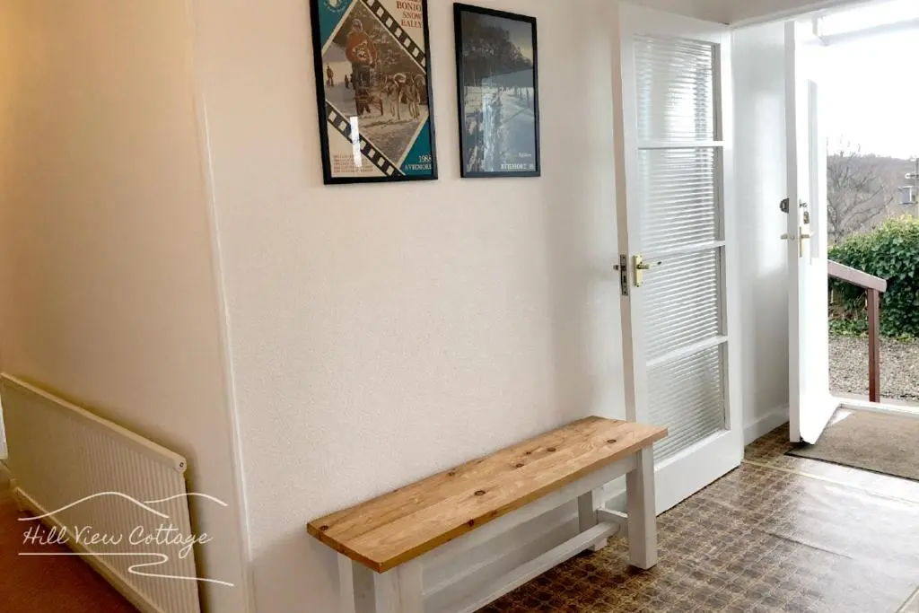 a hallway with a wooden bench on the wall at Hill View Cottage - near Aviemore in Aviemore