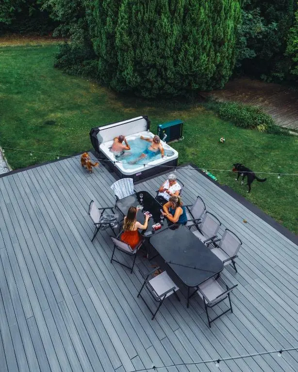 a group of people sitting around a table next to a pool at FAMILY FRIENDLY, HOT TUB, Fire Pit, Spacious & Modern in Fochabers