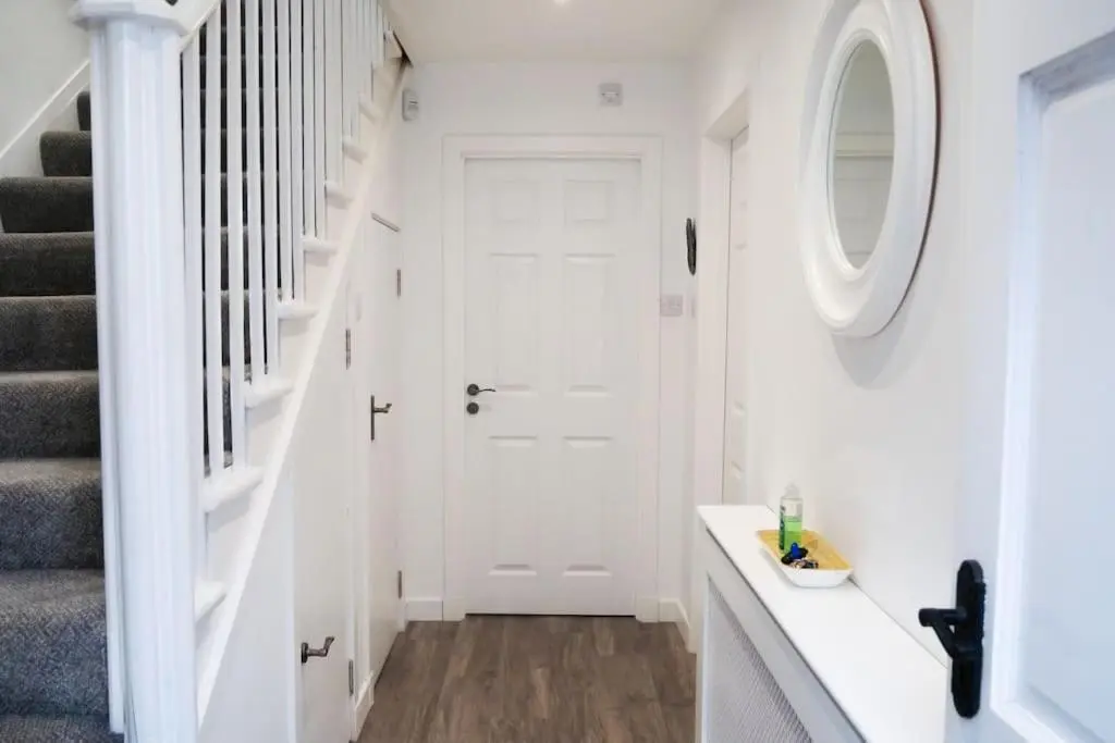 a white hallway with a white door and a round mirror at Central 2 bedroom luxury home close to River Ness in Inverness