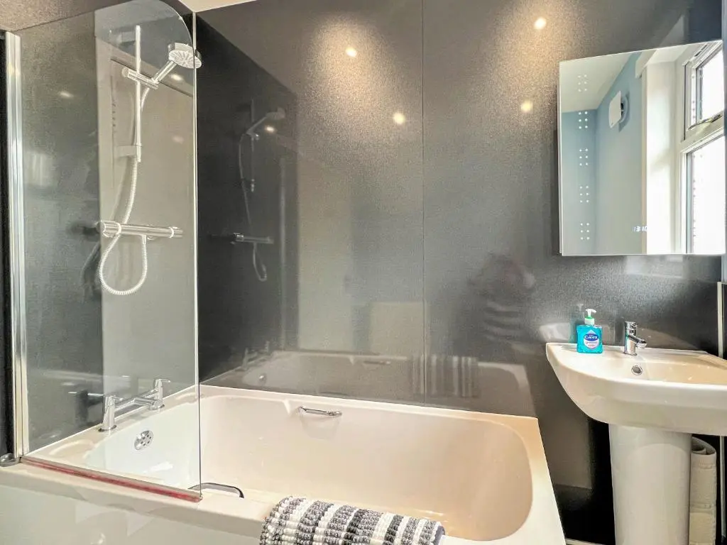 a bathroom with a shower and a tub and a sink at Westerdales in Fort Augustus