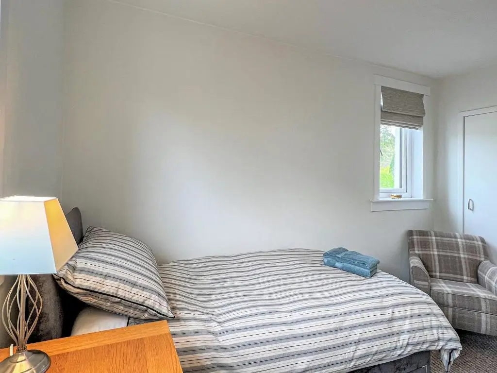 a bedroom with a bed and a chair at Westerdales in Fort Augustus