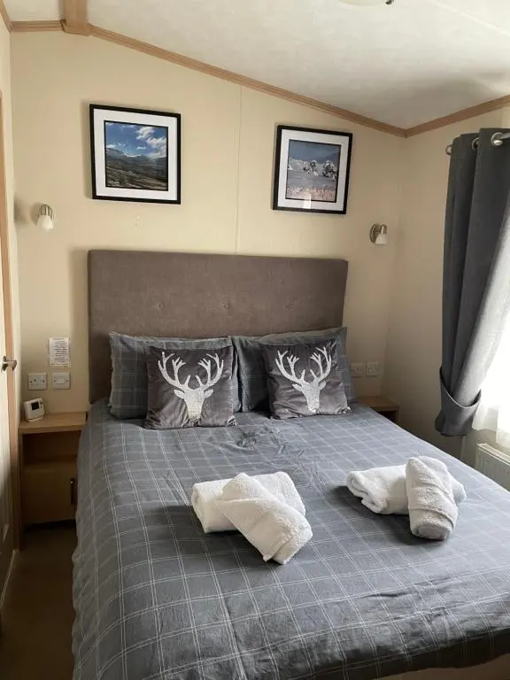a bedroom with a bed with two towels on it at Freedom Lodge-Aviemore with FREE Starlink Superfast broadband 150mbps - All bedding and towels included - Pet Free in Aviemore