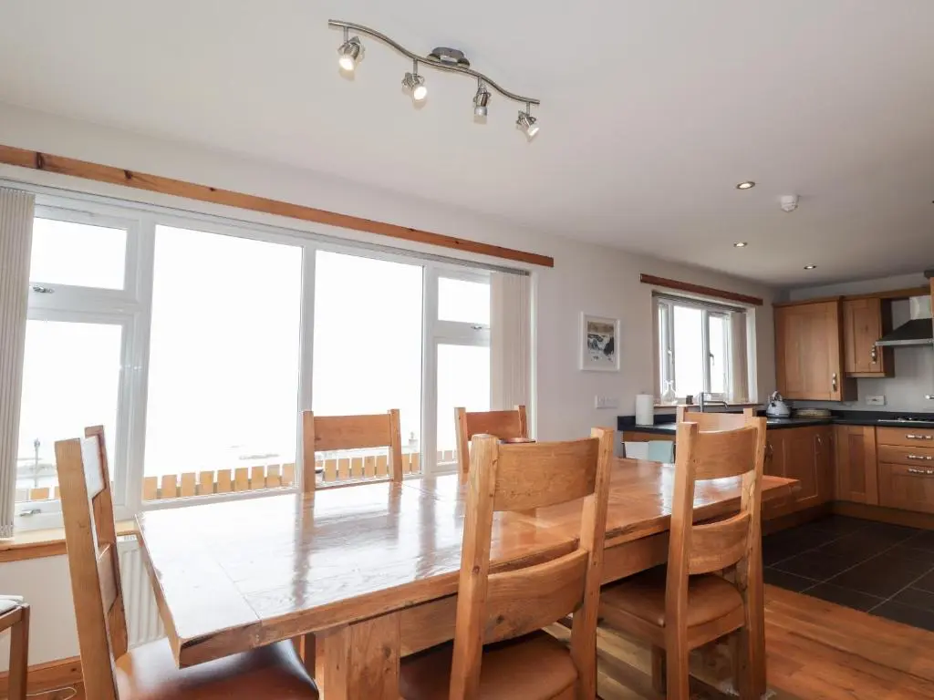 a kitchen with a wooden table and chairs at Learig in Buckie