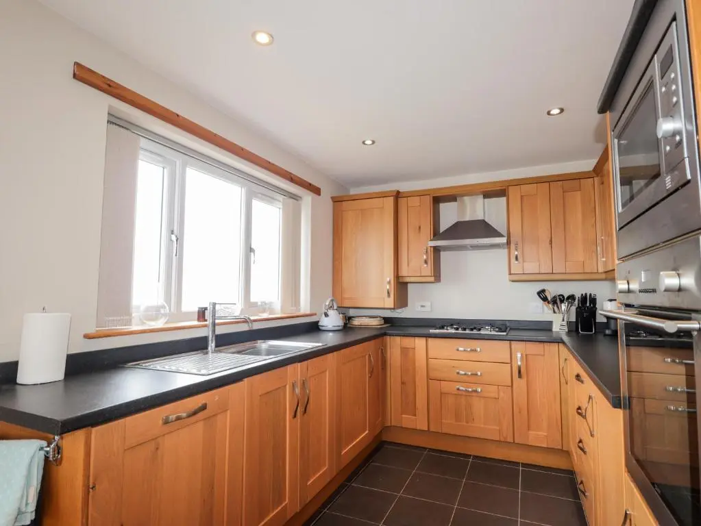 a kitchen with wooden cabinets and a sink and a window at Learig in Buckie