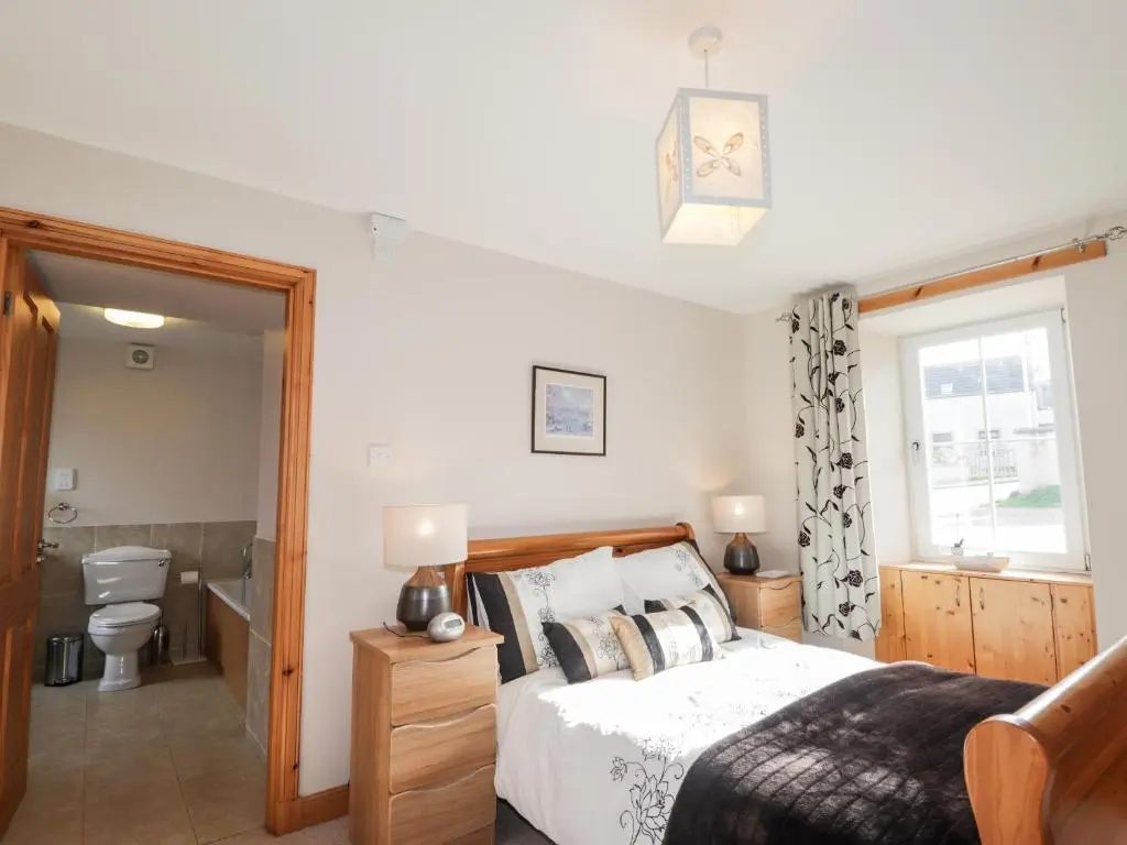 a bedroom with a bed and a bathroom at Learig in Buckie