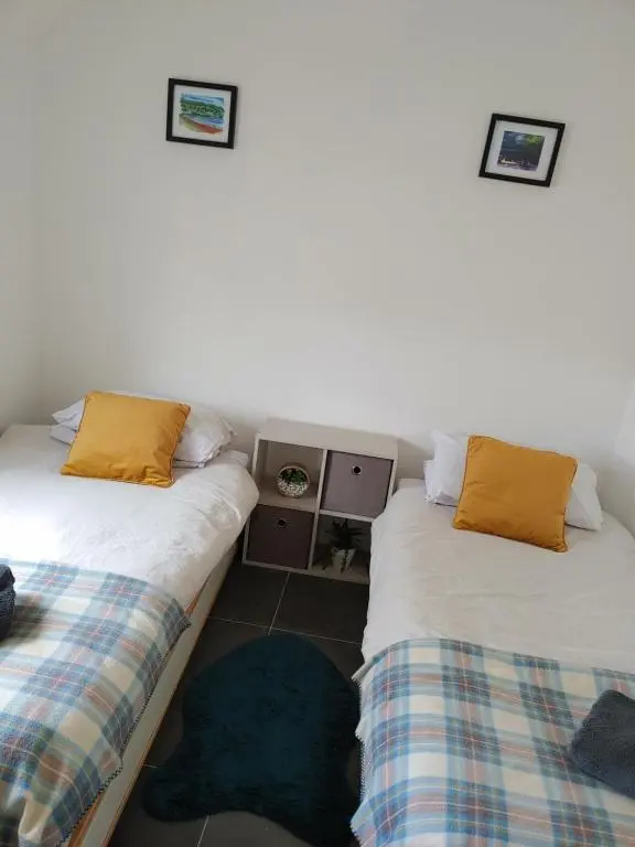 two beds sitting next to each other in a room at Cosy 2 Bedroom Croft Cottage with Beautiful Views in North Kessock