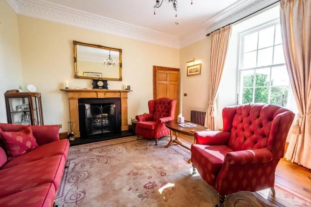 a living room with red furniture and a fireplace at Assynt House - Exclusive Use Holiday House in Dingwall