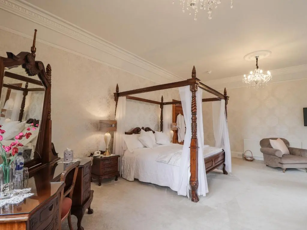 a bedroom with a canopy bed and a couch at Ledgowan Lodge Hotel in Achnasheen