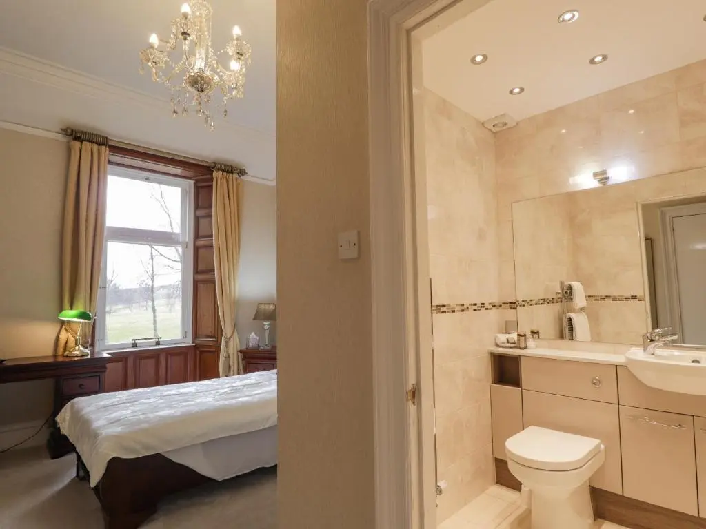 a bathroom with a bed and a sink and a toilet at Ledgowan Lodge Hotel in Achnasheen