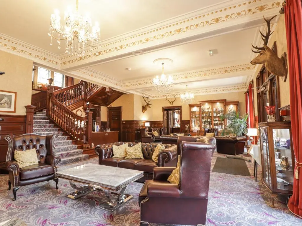 a living room with furniture and a chandelier at Ledgowan Lodge Hotel in Achnasheen