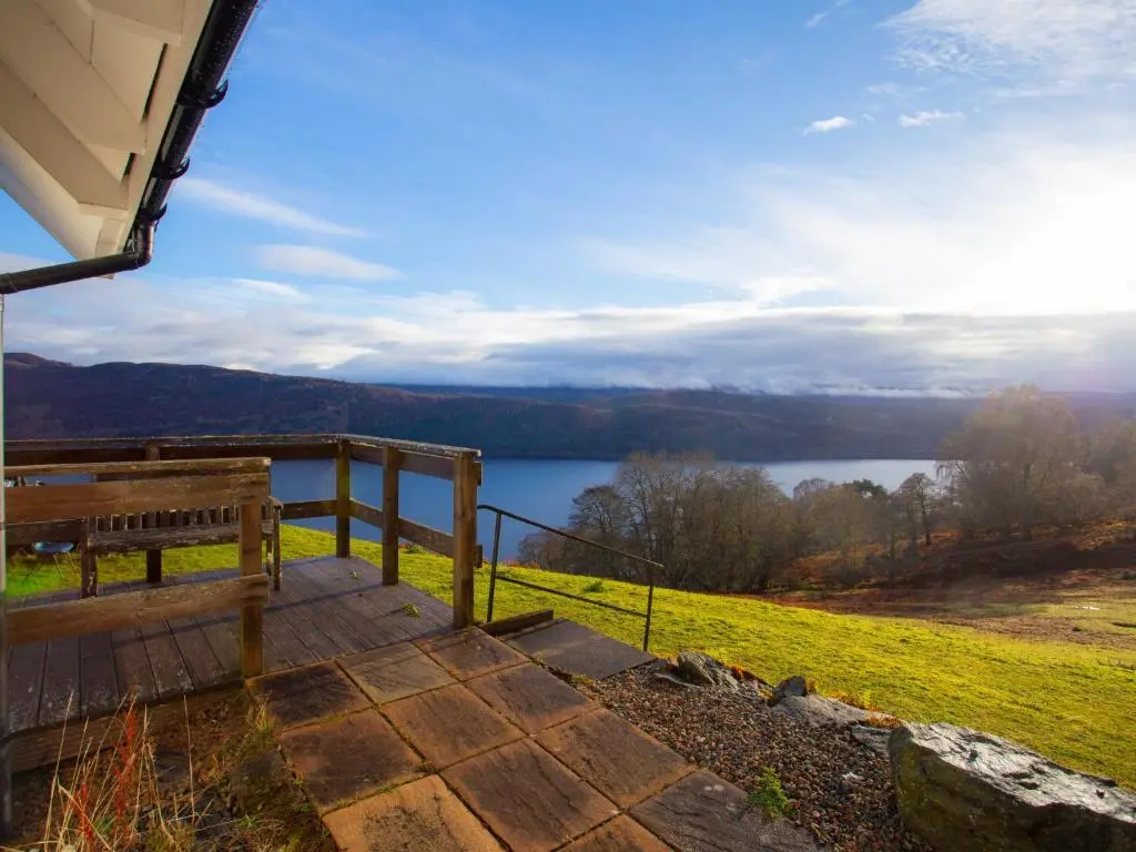 a porch with a bench and a view of a lake at Holiday Home Peter's Shed by Interhome in Drumnadrochit