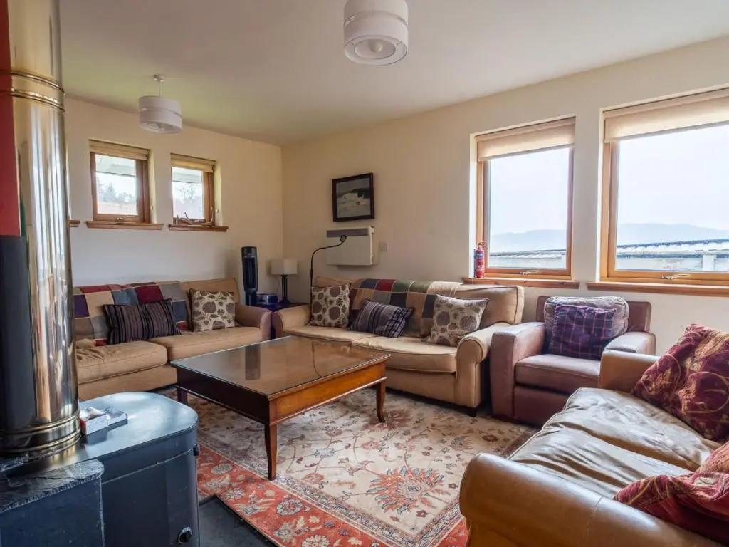 a living room with couches and a coffee table at Holiday Home Peter's Shed by Interhome in Drumnadrochit