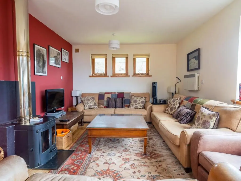 a living room with a couch and a fireplace at Holiday Home Peter's Shed by Interhome in Drumnadrochit