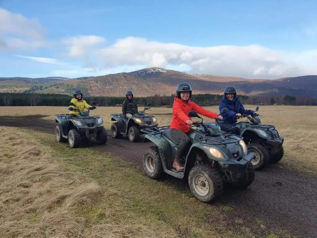 a group of people riding atvs on a dirt road at Stag's Hide in Aviemore