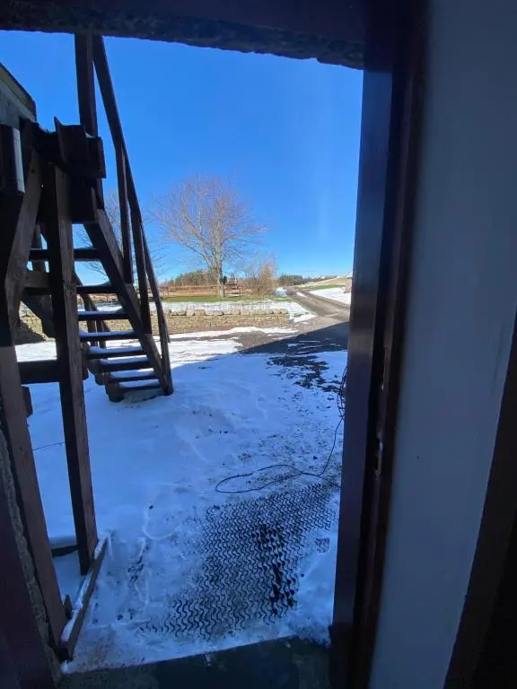 an open door to a room with snow on the ground at Ben View Aberlour Luxury Barn Conversion in Aberlour