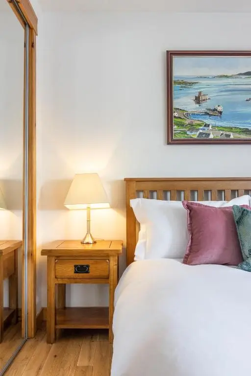 a bedroom with a bed and a table with a lamp at The Rooftops Reservation in Inverness