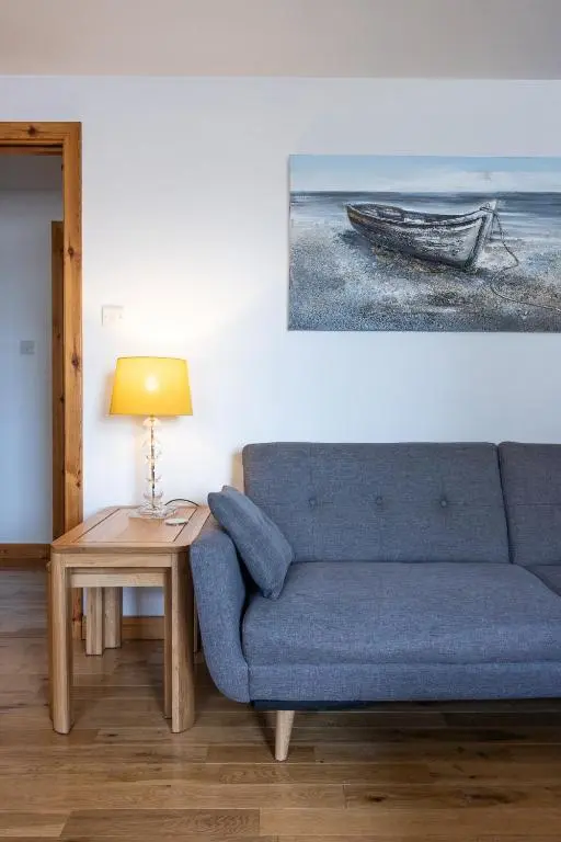 a living room with a blue couch and a table at The Rooftops Reservation in Inverness