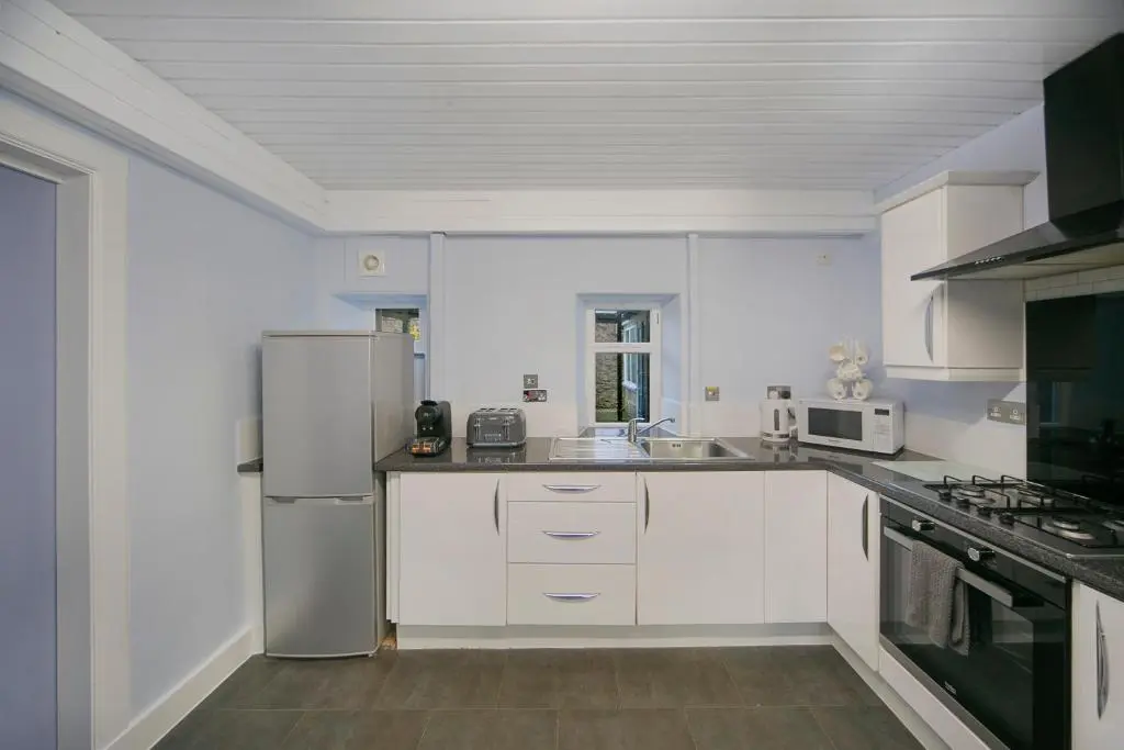 a kitchen with white cabinets and a stainless steel refrigerator at Constancevilla B9 - Grampian Lettings Ltd in Aberdeen